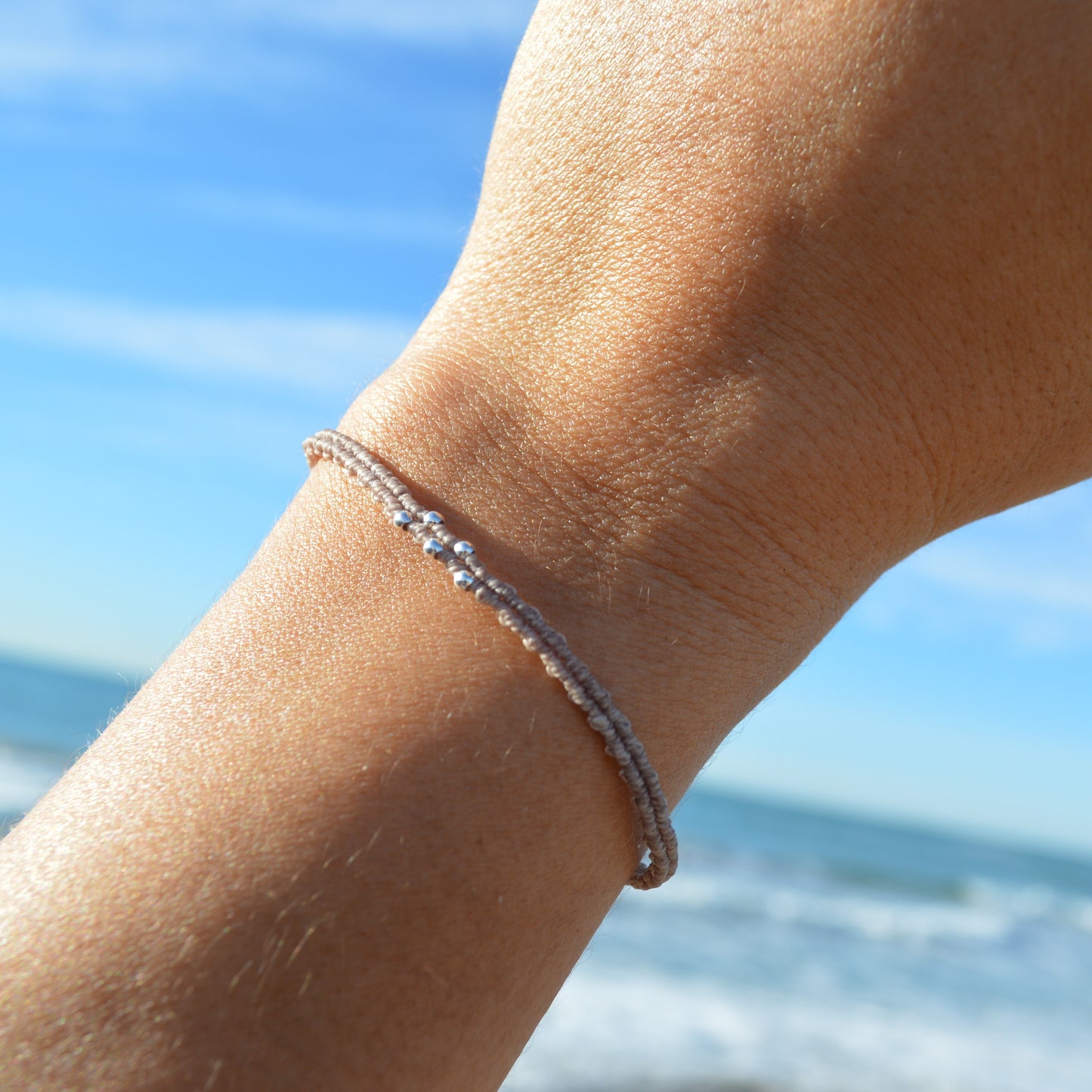 Pulsera de Macramé Minimalista con Cuentas Plateadas y Botón de Guijarro